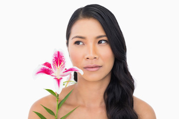 Pretty natural brown haired model posing with lily