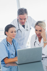Cheerful doctors working together on laptop