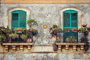 Fototapety  Piękny balkon w stylu vintage z kolorowymi kwiatami i drzwiami