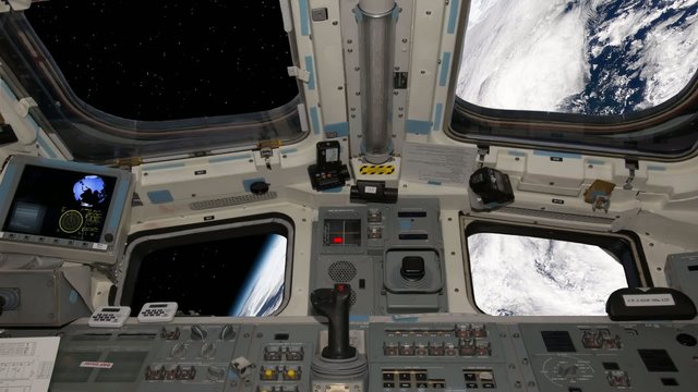 View of the space shuttle cockpit orbiting earth.