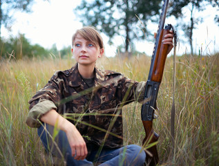 Young beautiful girl with a shotgun