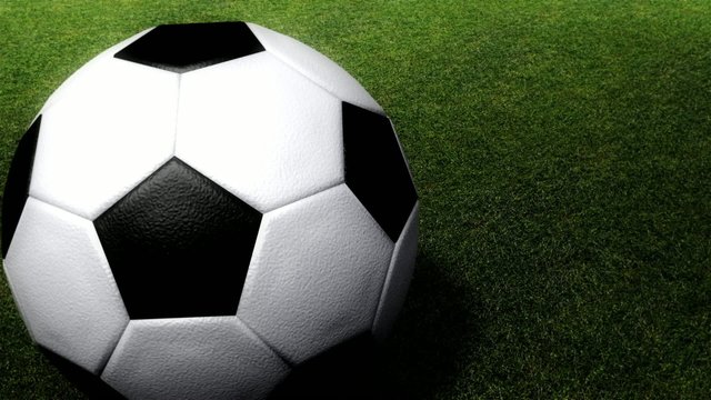 Soccer ball rolling on a grass field, Looping animation