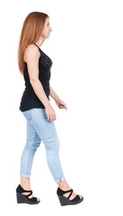 back view of walking  woman. beautiful redhead girl in motion.