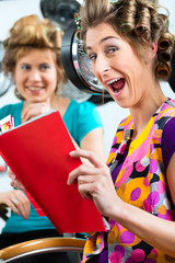 Women at the hairdresser with hair dryer