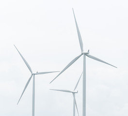 wind turbine in wind farm against cloudy sky