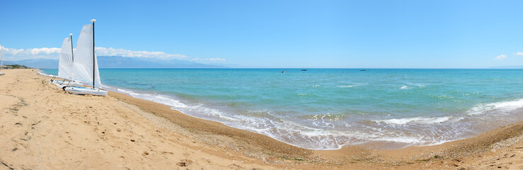 Fototapeta na wymiar Panorama of sail yachts on the beach on Ionian Sea at luxury hot
