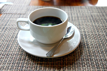 Black coffee in a white cup on the table.