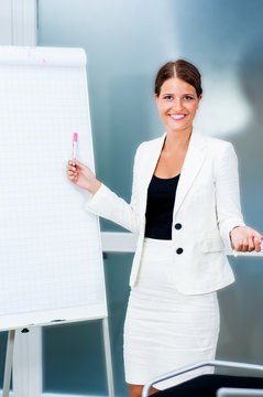 Junge Gesch&auml;ftsfrau pr&auml;sentiert an Flipchart