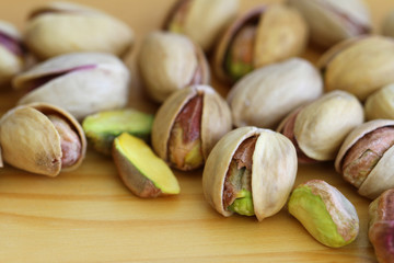 Pistachio nuts with and without shell on wooden surface