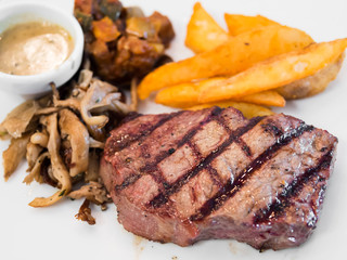 Rib eye steak meal with french fries and mushroom