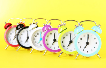 Colorful alarm clock on yellow background
