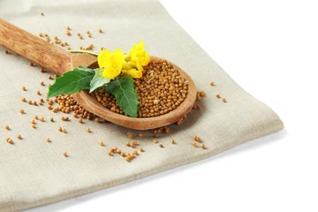 Fotobehang Mustard seeds in wooden spoon with mustard flower isolated © Africa Studio