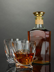 Glass of whiskey with bottle, on dark background