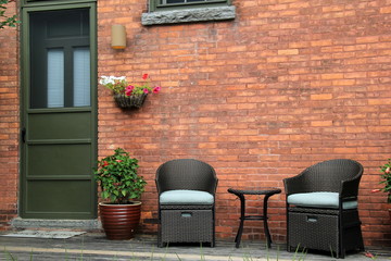 Comfy chairs and potted plants on front porch