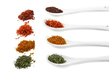 Keuken spatwand met foto Assortment of spices in  white spoons, isolated on white © Africa Studio