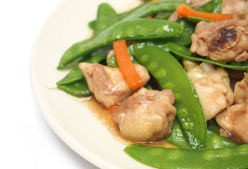 Stir fried snow peas and chicken on plate