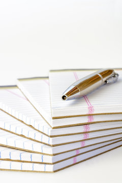 Stack of paper tablets with a pen