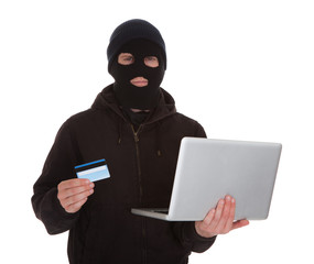 Burglar Holding Credit Card And Laptop