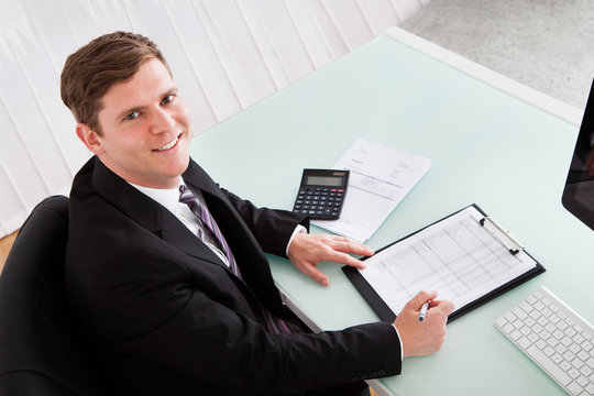 Happy young man calculating finances