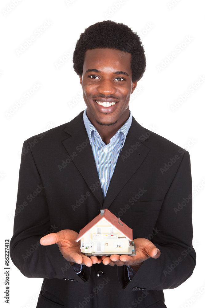 Wall mural african businessman holding house model