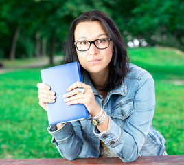 Beautiful young woman with book in park