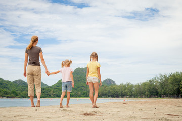 mother and two daughters walking on the beach