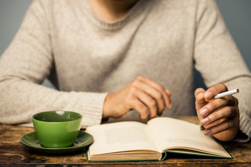 Man is reading and smoking in cafe