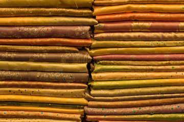 Heap of cloth fabrics at a local market in India. Close up .