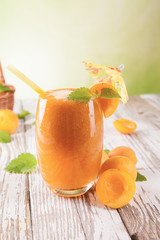 Fresh apricot drink on wood