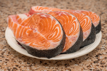 Raw fillet of fresh salmon fish on white plate