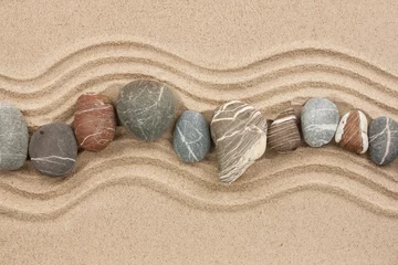 Fotobehang Gestreepte stenen op het zand © alekleks