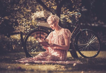 Blond beautiful retro woman reading book 