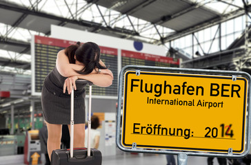 verzweifelte Frau und Schild - Flughafen Berlin Brandenburg
