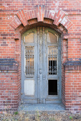 Old dilapidated door in masonry house front