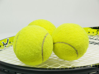 Black and yellow tennis rocket with three yellow balls