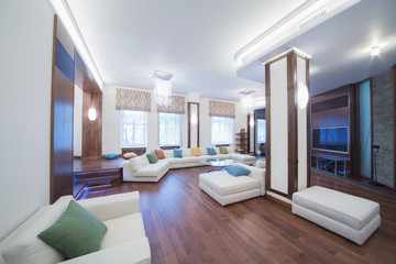 The spacious, well lit living room with round glass table