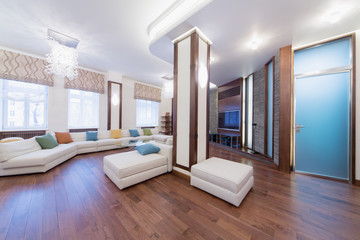 The spacious, well lit living room with round glass table
