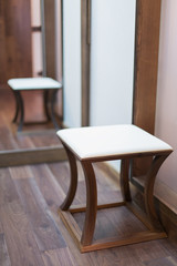 Low square stool with a padded seat in modern interior