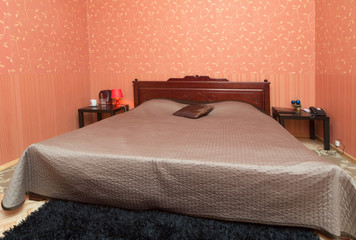 Simple interior of a small bedroom with a large bed