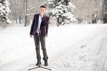 The singer in a suit and a scarf stands and sing outdoors