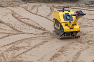 Plate compactor at a construction site.