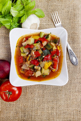 Top view of tomato and pepper dish on hessian background