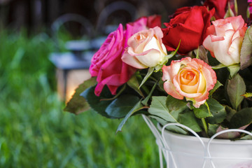 Bouquet of roses, garden party, lanterns on grass in the back