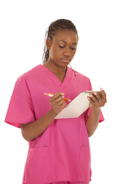 Woman Pink Scrubs Writing Down