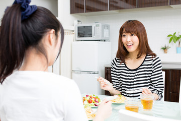 Obraz na płótnie Canvas beautiful asian women eating in the kitchen