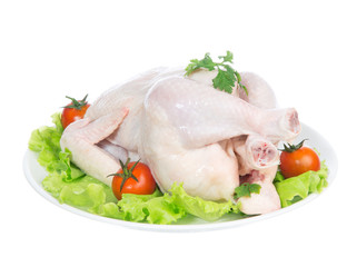 Raw crude chicken on a plate garnished with vegetables salad