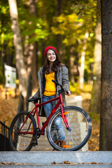 Fototapeta na wymiar Urban biking - girl and bike in city park