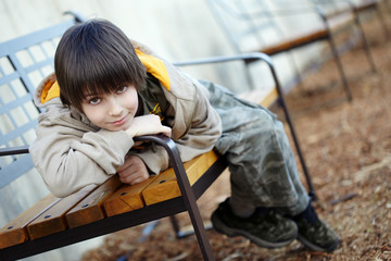 A boy sitting in a park