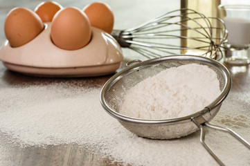 Flour in a sieve  on kitchen table.