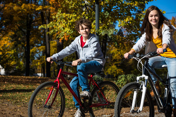Fototapeta premium Urban biking - teens riding bikes in city park